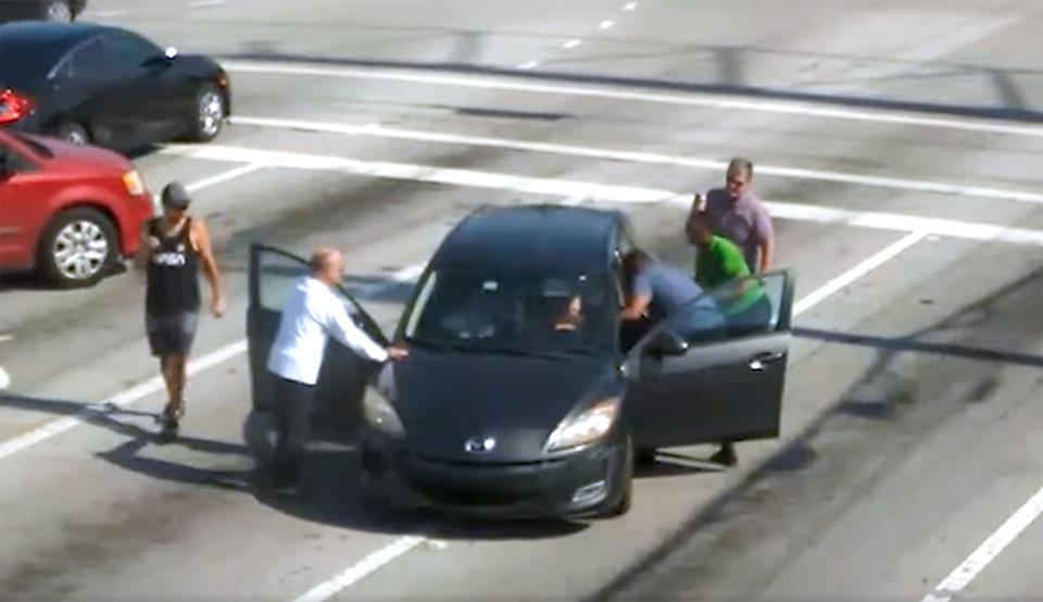 Bystanders smashed the vehicle's rear window to open the car, and reached in to assist the woman. (Boynton Beach Police Department  / Facebook)