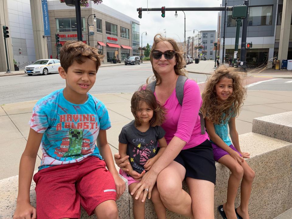 Sara Kanevsky Khan and her children, from left, Tarek, Lila and Naia, try to stay cool on the Worcester Common Thursday.