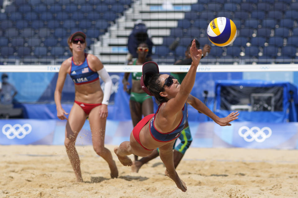 Sarah Sponcil, right, of the United States, stretches out for the ball as teammate Kelly Claes looks on during a women's beach volleyball match against Kenya at the 2020 Summer Olympics, Thursday, July 29, 2021, in Tokyo, Japan. (AP Photo/Petros Giannakouris)