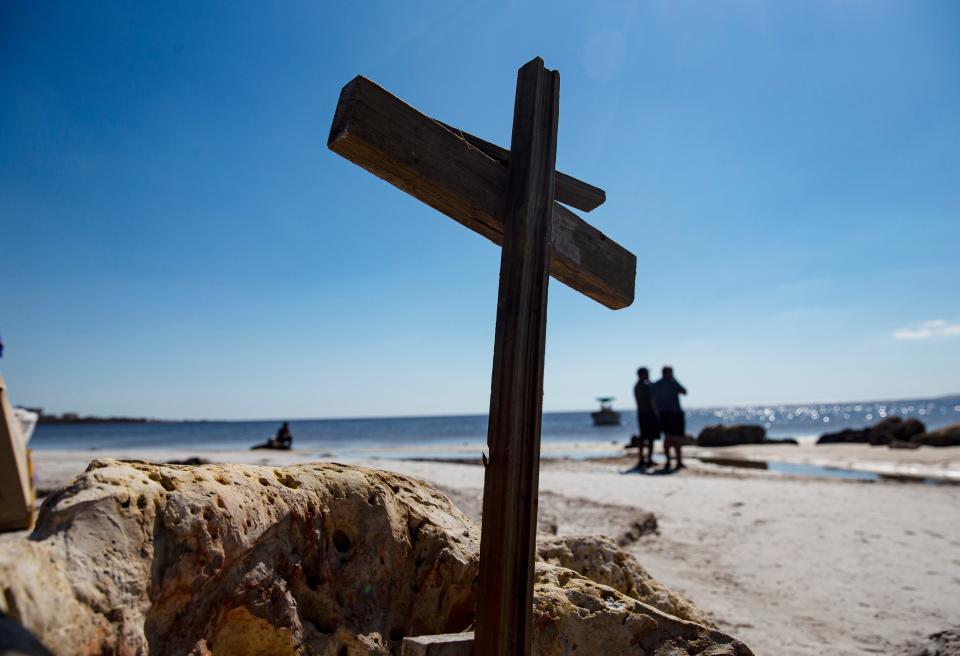 Pieces of wood depicting a cross was installed in rocks at Bunche Beach on the end of John Morris Road on Friday, Oct. 27, 2022. The area sustained heavy damage from Hurricane Ian.  