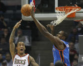 Milwaukee Bucks' Monta Ellis, left, has his shot blocked by Oklahoma City Thunders' Serge Ibaka during the first half of an NBA basketball game Monday, April 9, 2012, in Milwaukee. (AP Photo/Jeffrey Phelps)