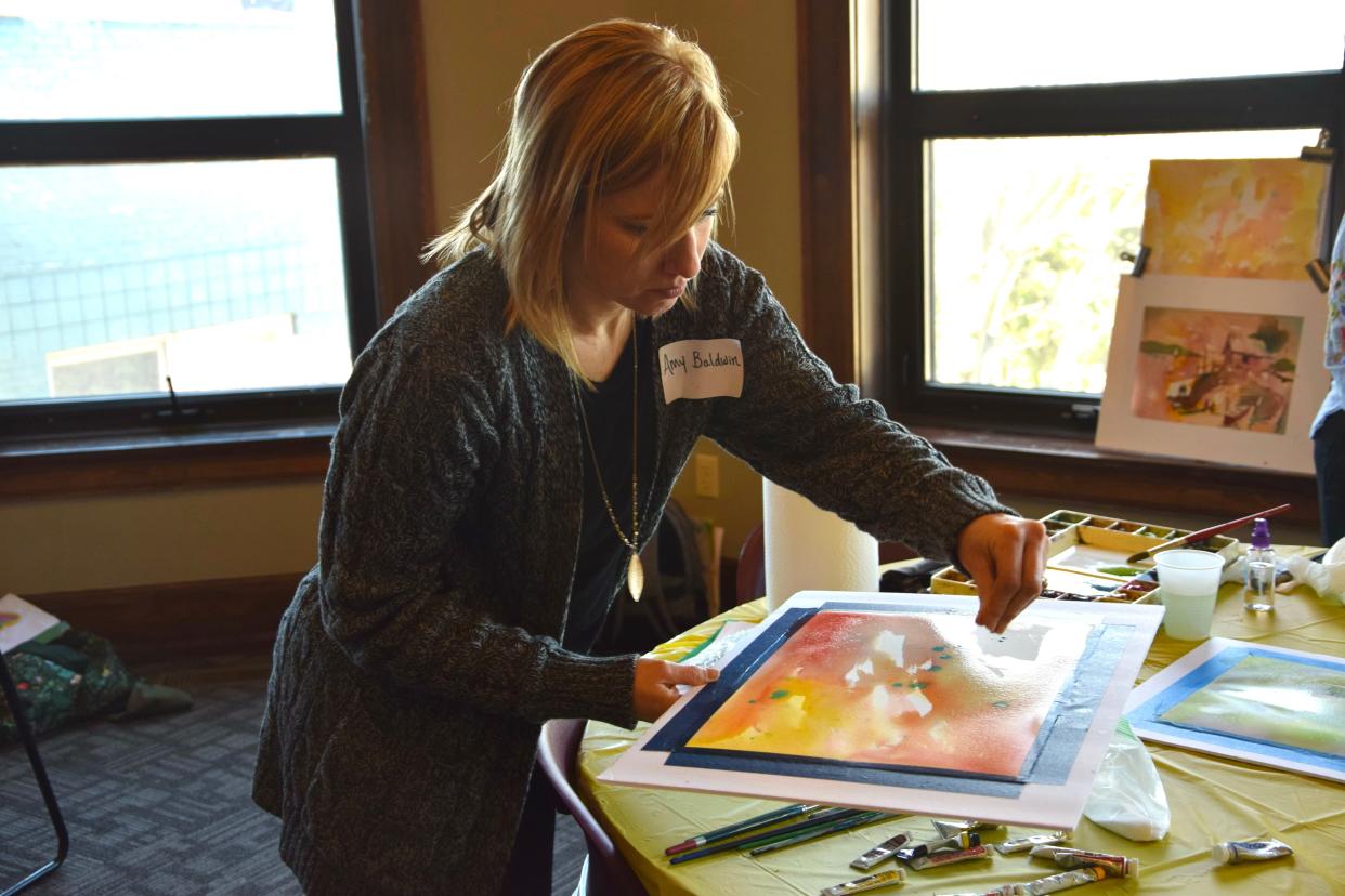 Amy Baldwin, art teacher from St. Mary School, sprinkles salt over her watercolor painting during Crooked Tree Art Center's professional development day on April 15, 2024.