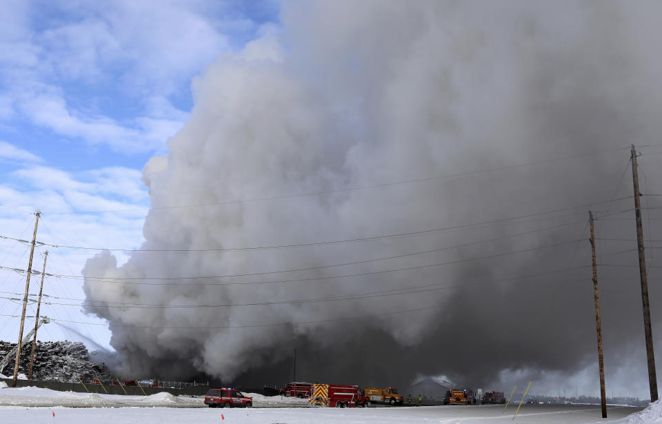 Firefighters on Wednesday morning remained on the scene of a fire that has been burning for more than 24 hours at the Northern Metal Recycling plant in Becker, Minn. Firefighter Toni Knutson says the fire is burning under a huge pile of cars. She says cranes are being used to remove the vehicles from the pile one-by-one. (David Joles/Star Tribune via AP)