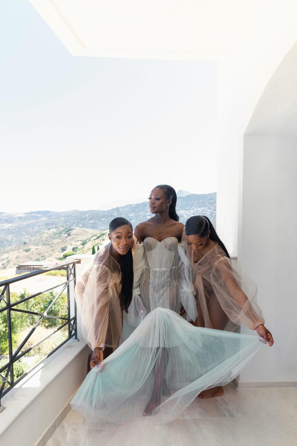 Two women adjust a bride's dress.