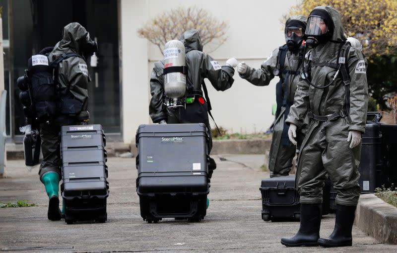 South Korean soldiers from a chemical corps prepare to carry out quarantine works at an apartment complex in Daegu