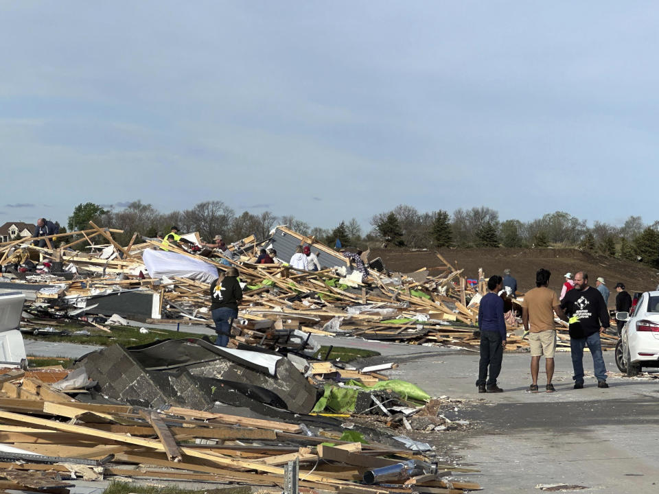 People are pick through the rubble of a house that was leveled in Elkhorn, Neb., on Saturday, April 27, 2024. Residents began sifting through the rubble after a tornado plowed through suburban Omaha, demolishing homes and businesses as it moved for miles through farmland and into subdivisions. (AP Photo/Nicholas Ingram)