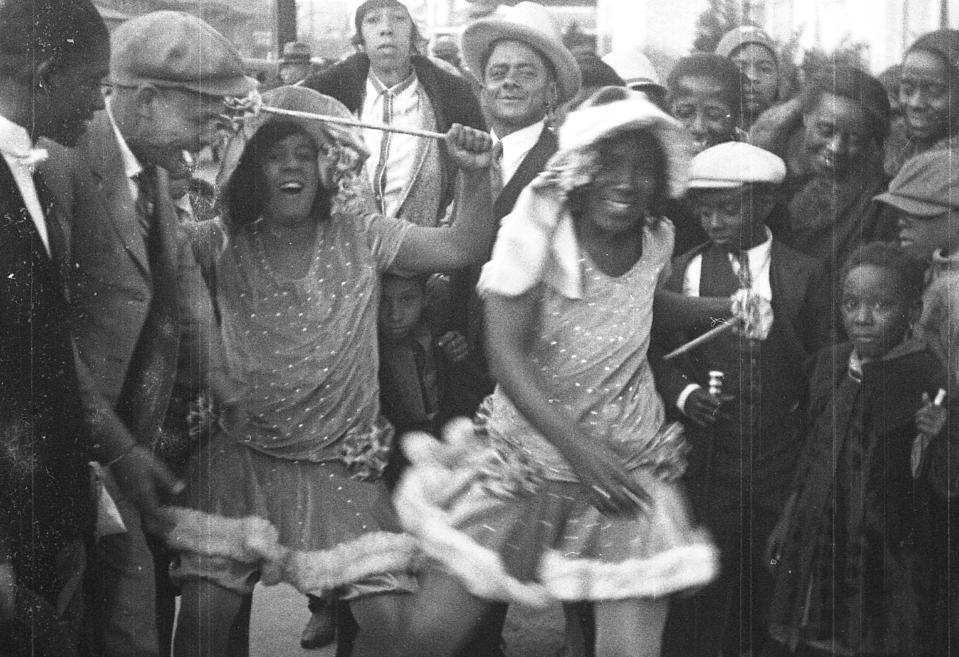 This still frame from a film strip provided by Story Sloan Gallery shows women dressed as "baby dolls" dancing on a New Orleans street at Mardi Gras in 1931. The first known group of women to strut and dance in short “baby doll” dresses was a group of African-American prostitutes who wanted to outdo another group in 1912, but the style soon spread to respectable black neighborhoods and is seeing a modern revival. (AP Photo/Story Sloan Gallery)