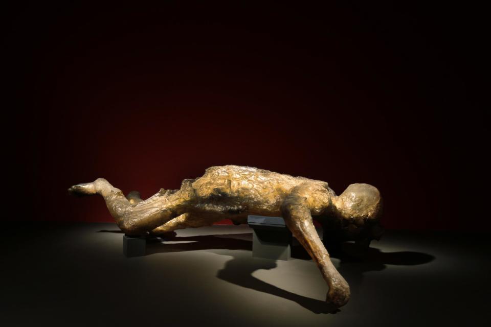 A cast of a woman, one of more than 70 people who died in the basement of a villa in Oplontis, near Pompeii, is seen during a photo call for the upcoming exhibition entitled 'Life and death Pompeii and Herculaneum', at the British Museum in central London, Tuesday, March 26, 2013. The void her body left in the ash was filled with clear epoxy resin, and he resulting cast reveals her skeleton and the jewelry she was wearing. The exhibition about the two Roman cities, buried by a catastrophic volcanic eruption of Mount Vezuvius in 79 AD, will run at the museum from March 28 to Sept. 29, 2013. (AP Photo/Lefteris Pitarakis)