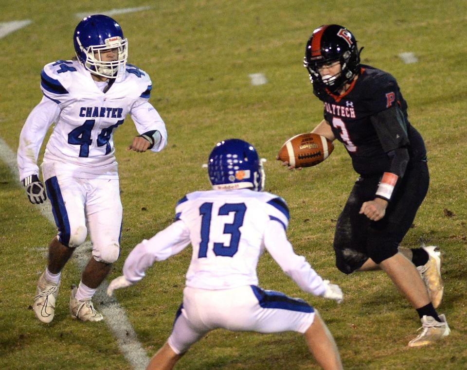 Charter of Wilmington defenders Rocco Rapposelli (44) and Joseph Meara (13) close in on Polytech quarterback Isaac Balcerak during a 10-0 win in the DIAA Class 1A semifinals on Nov. 24.