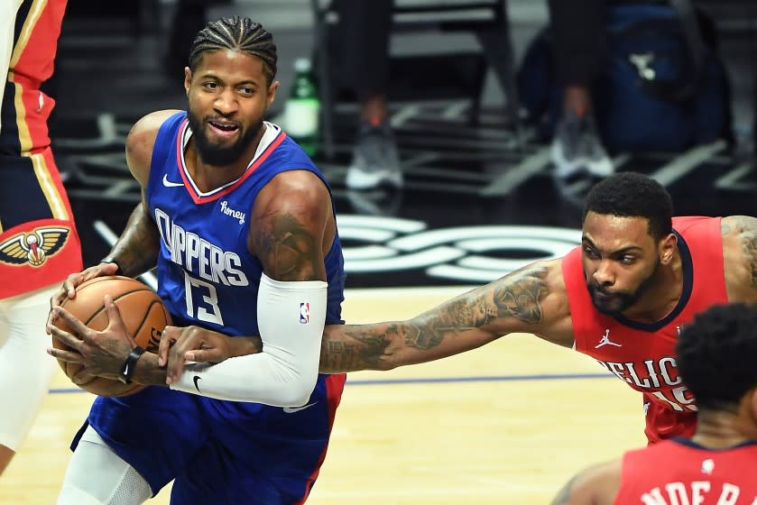 LOS ANGELES, CALIFORNIA JANUARY 13, 2021-Clippers Paul George is fouled by Pelicans Sindarius Thornwell in the 1st quarter at the Staples Center Wednesday. (Los Angeles Times/Wally Skalij)