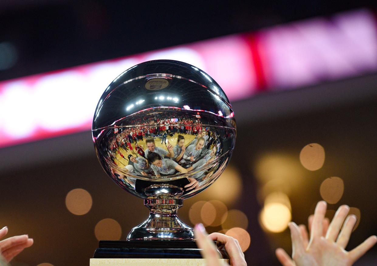 The USD women's basketball team holds up their Summit League championship trophy for a crowd of fans to see on Tuesday, March 10, at the Denny Sanford Premier Center in Sioux Falls.