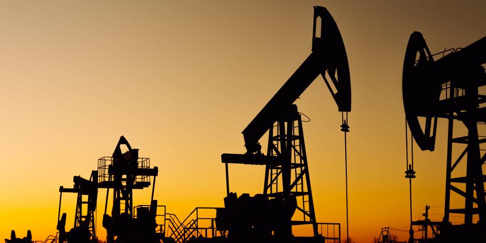 The silhouette of two oil pumps - stock photo.