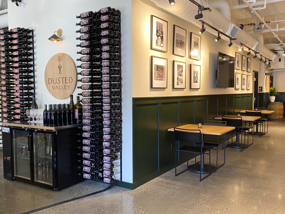 A custom sign and wine racking create a beautiful focal point behind the bar.
