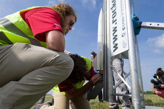 Niles Butts looks on as his teammate makes a final rocket adjustment during the International Rocketry Challenge, where his Alabama team took first place.