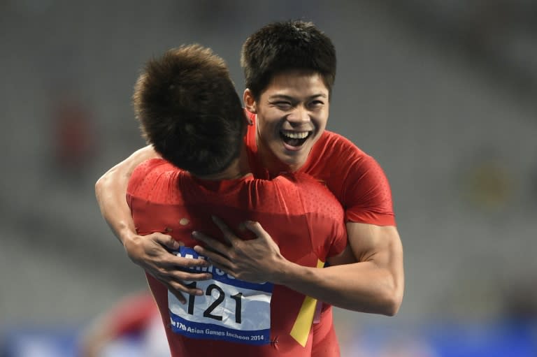 China's Zhang Peimeng (L) celebrates with compatriot Su Bingtian after their victory in the final of the men's 4x100m relay athletics event during the 17th Asian Games at the Incheon Asiad Main Stadium in Incheon on October 2, 2014