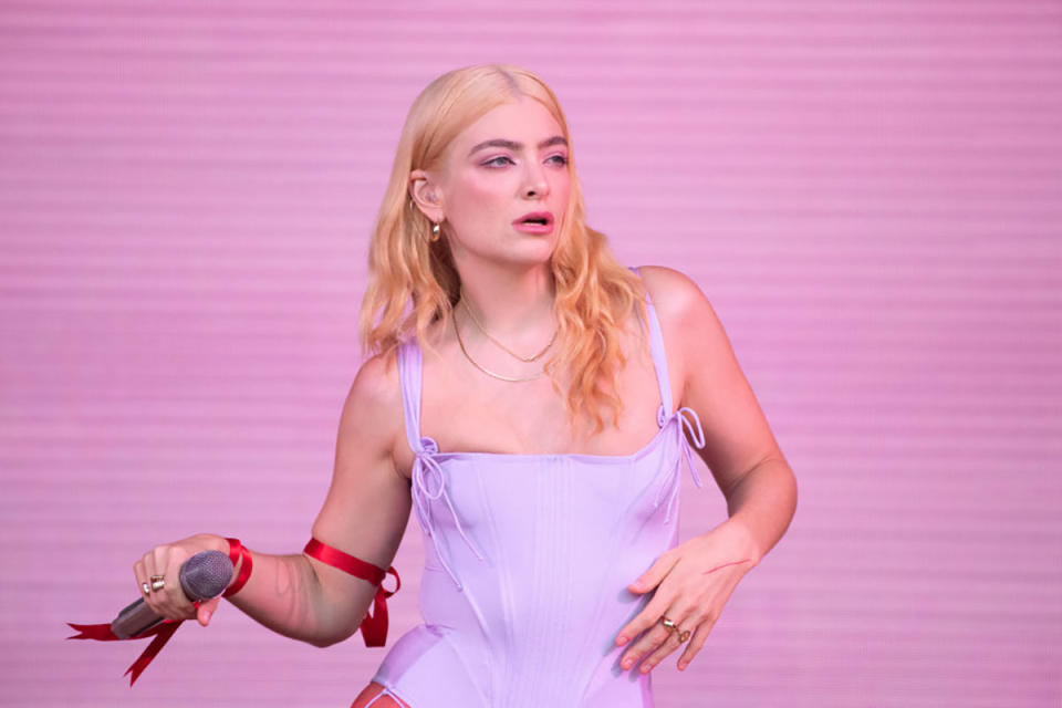 Lorde on the Glastonbury 2022 stage, wearing a lilac corset and sporting blonde hair