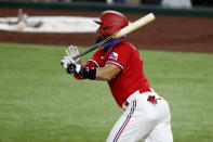 Texas Rangers' Robinson Chirinos follows through on a run-scoring sacrifice fly in the second inning of a baseball game against the Los Angeles Angels in Arlington, Texas, Friday, Aug. 7, 2020. The Rangers' Willie Calhoun scored on the play. (AP Photo/Tony Gutierrez)