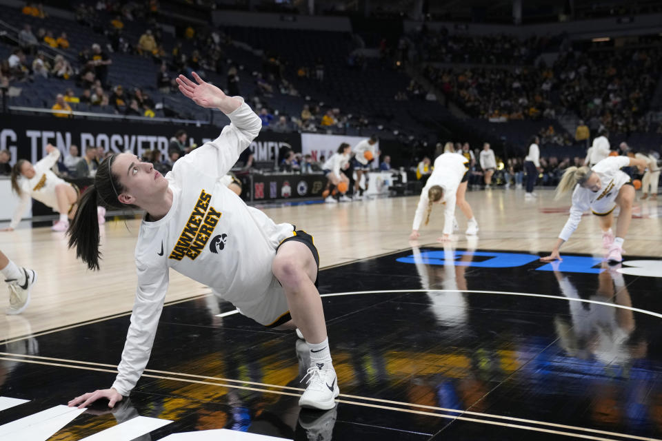 Iowa guard Caitlin Clark, left, warms up before an NCAA college basketball quarterfinal game against Penn State at the Big Ten women's tournament Friday, March 8, 2024, in Minneapolis. (AP Photo/Abbie Parr)