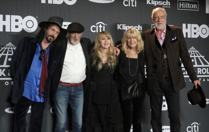 A group of people smiling and posing with their arms around each other in a line