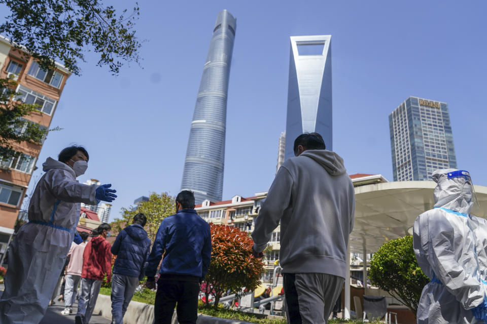 In this photo released by Xinhua News Agency, residents wait to take nucleic acid tests at a community in Pudong New Area of eastern China's Shanghai city on Monday, April 4, 2022. China has sent more than 10,000 health workers from across the country to Shanghai, including 2,000 military medical staff, as it struggles to stamp out a rapidly spreading COVID-19 outbreak in China's largest city.(Ding Ting/Xinhua via AP)