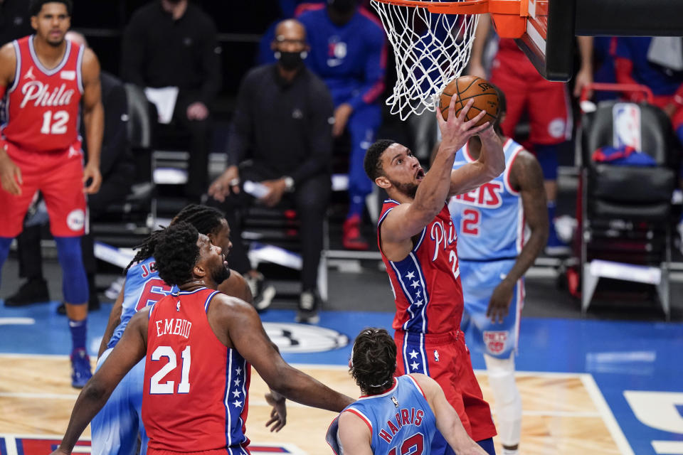 Philadelphia 76ers' Ben Simmons drives past Brooklyn Nets' Joe Harris as 76ers' Joel Embiid (21) watches during the first half of an NBA basketball game Thursday, Jan. 7, 2021, in New York. (AP Photo/Frank Franklin II)