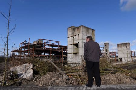 A man stands in front of a building site for a hotel that was never completed in Edenderry, Ireland February 18, 2016. REUTERS/Clodagh Kilcoyne