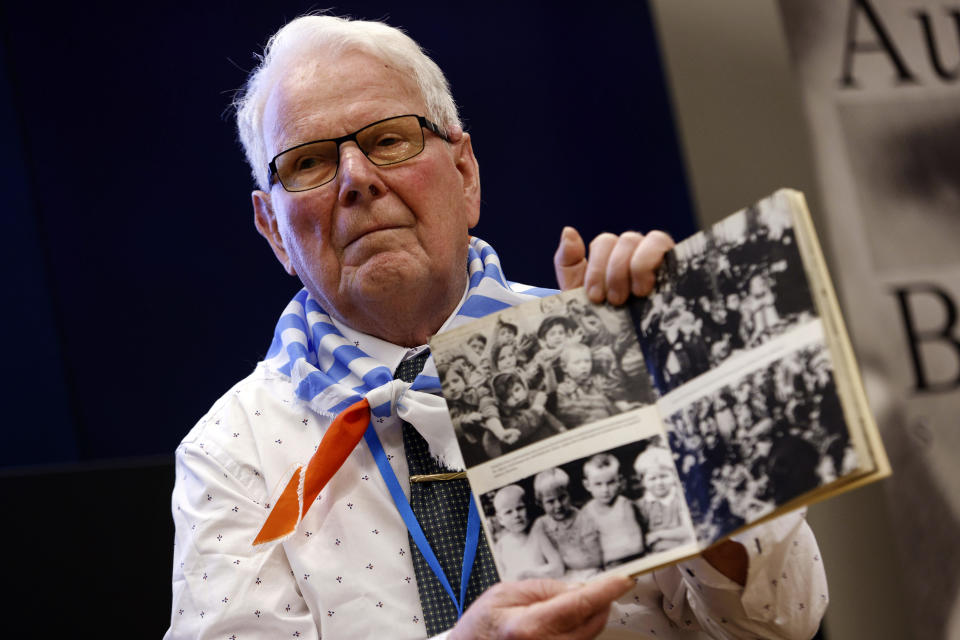 Holocaust survivor Grzegorz Tomaszewski shows a book with photographs as he attends a meeting of survivors with media in Oswiecim, Poland, Thursday, Jan. 26, 2023. Survivors of Auschwitz-Birkenau are gathering to commemorate the 78th anniversary of the liberation of the Nazi German death camp in the final months of World War II, amid horror that yet another war has shattered the peace in Europe. The camp was liberated by Soviet troops on Jan. 27, 1945. (AP Photo/Michal Dyjuk)