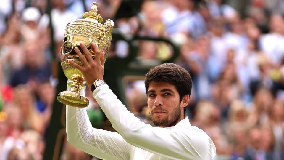 Carlos Alcaraz lifts the men's singles trophy at Wimbledon in 2023. - Clive Brunskill/Getty Images