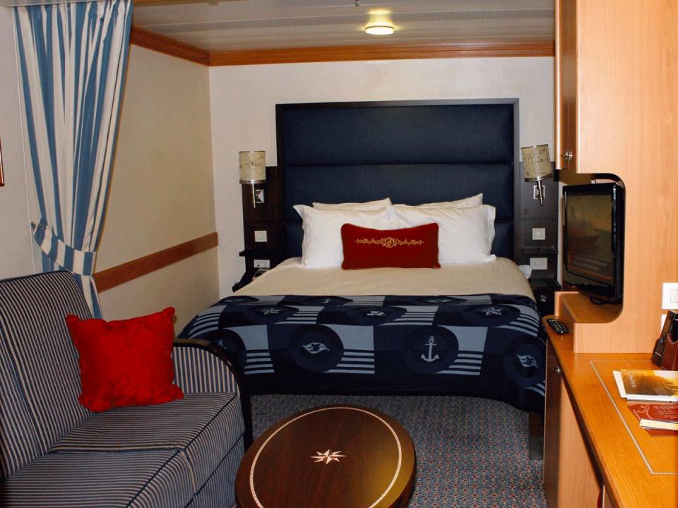 The inside stateroom on the Disney Magic cruise ship with a bed and a couch divided by a curtain