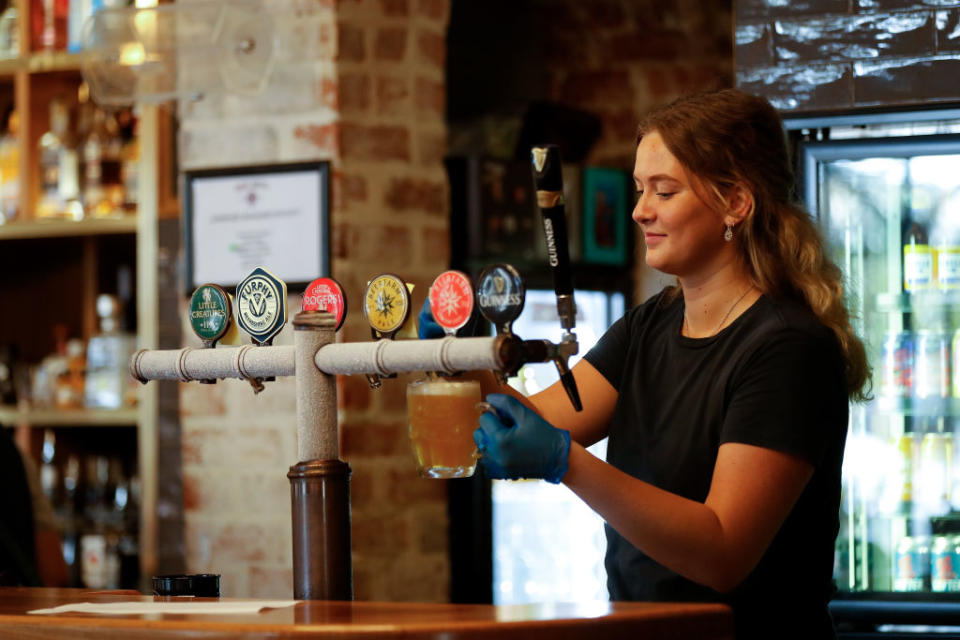 BUNBURY, AUSTRALIA - MAY 18: A Bartender pours a beer for their customers at the Rose Hotel in Bunbury on May 18, 2020 in Bunbury, Australia. COVID-19 restrictions have further eased across Western Australia in response to the state's declining infection rate. From Monday 18 May, restaurants and cafes can open for up to 20 patrons to dine in, while indoor and outdoor gatherings of up to 20 people are also permitted. Regional travel boundaries have also been eased, with temporary regional borders reduced from 13 to four. Travel is permitted within the Mid-West, Gascoyne and Pilbara, the Goldfields-Esperance region and within the Kimberley. While travel between South West, Great Southern, Wheatbelt and Peel regions to Perth is also now permitted.Travel between Perth and the other regions remains prohibited, and Western Australia's interstate border also remains closed. (Photo by James Worsfold/Getty Images)