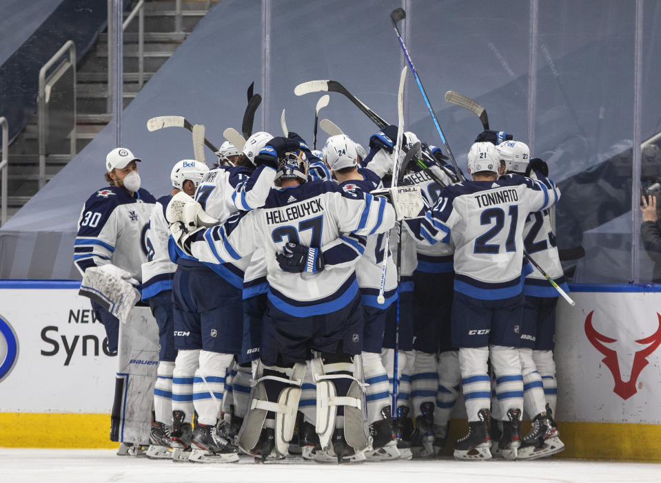 Winnipeg Jets celebrate an overtime win over the Edmonton Oilers in Game 2 of an NHL hockey Stanley Cup first-round playoff series Friday, May 21, 2021, in Edmonton, Alberta. (Jason Franson/The Canadian Press via AP)