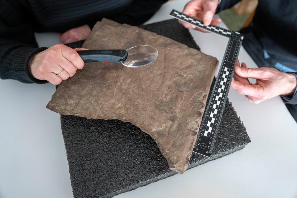 Researchers at the Museum of Cultural History in Oslo, Norway, inspect a rune stone with inscriptions that are up to 2,000 years old and date back to the earliest days of the enigmatic history of runic writing