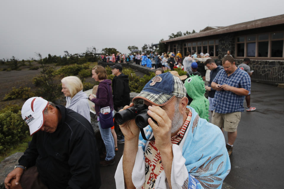 FILE - In this May 10, 2018, file photo, visitors view Kilauea's summit crater outside the Jaggar Museum in Volcanoes National Park, Hawaii. The Hawaii Volcanoes National Park will reopen its main gates Saturday, Sept. 22. The park has been closed for 135 days as volcanic activity caused explosive eruptions, earthquakes and the collapse of the famed Halemaumau crater. (AP Photo/Jae C. Hong, File)