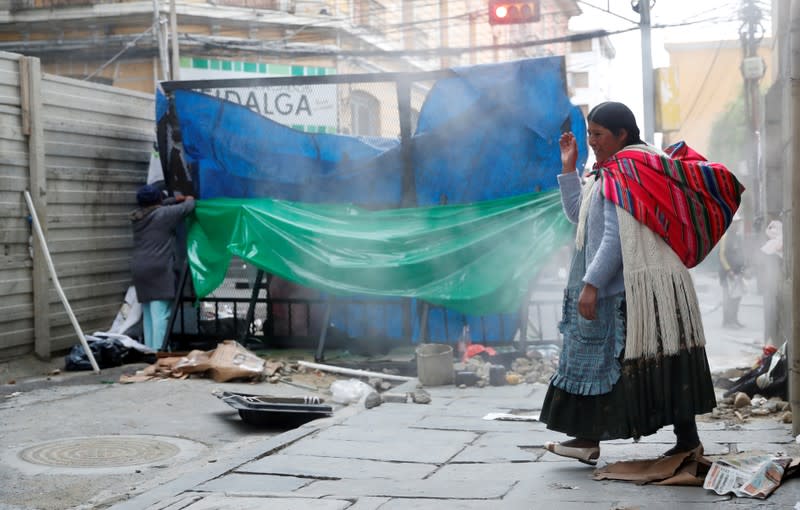 A woman passes a barricade, after Bolivia's former president Evo Morales left the country, in La Paz