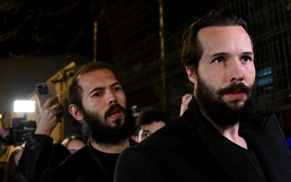 Andrew Tate (L) and his brother Tristan Tate walk out of the central arrest centre of Bucharest police after three months of pre-trial detention - DANIEL MIHAILESCU/AFP via Getty Images)