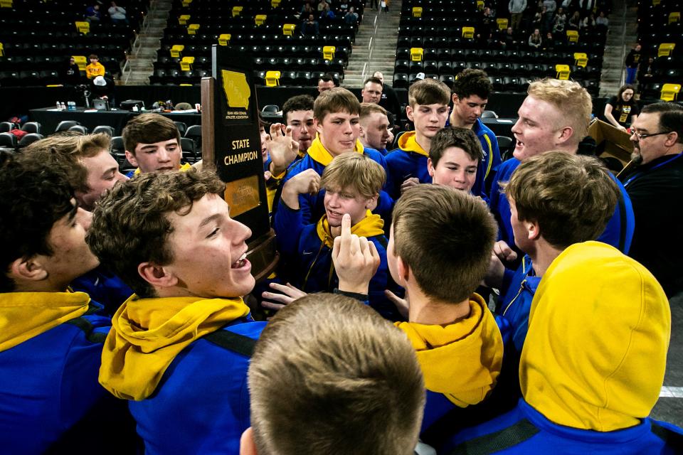 Don Bosco wrestlers celebrate with their trophy during the Class 1A boys state wrestling duals, Saturday, Feb. 4, 2023, at Xtream Arena in Coralville, Iowa.