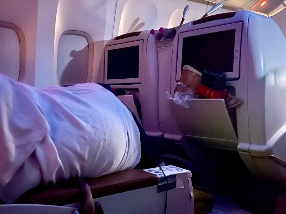 The view directly to the author's left shows a person sleeping in the adjacent aisle seat.
