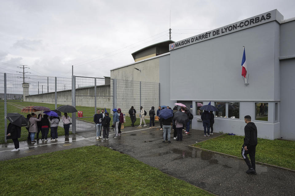 Prison workers gather during a protest outside the Corbas prison, outside Lyon, France, Wednesday, May 15, 2024 . A massive manhunt was underway in France on Wednesday for an armed gang that ambushed a prison convoy, killing two prison officers, seriously injuring three others and springing the inmate they were escorting. (AP Photo/Laurent Cirpiani)