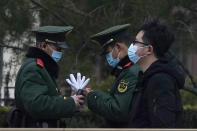 Chinese paramilitary policemen change shifts on the streets of Beijing near the Great Hall of the People Wednesday, March 3, 2021. In a sign of confidence China has reverted back to holding its annual Congress meetings to march this year after delaying them due to the outbreak of the coronavirus last year. As usual, security has been tightened in the capital with paramilitary troops patrolling near the Great Hall of the People where the meetings are held and standing guard at subway stations. (AP Photo/Ng Han Guan)