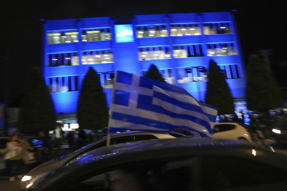 Supporters of Greece's Prime Minister and leader of New Democracy Kyriakos Mitsotakis drive past the party headquarters in Athens, Greece, Sunday, May 21, 2023. The conservative party of Greek Prime Minister Kyriakos Mitsotakis has won a landslide election but without enough parliamentary seats to form a government. (AP Photo/Thanassis Stavrakis)