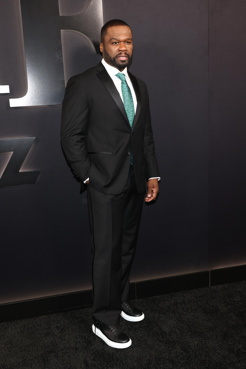 50 Cent wearing black suit and green tie.