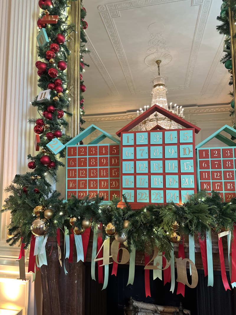 teal and red building on mantle with teal and red ribbons and garland