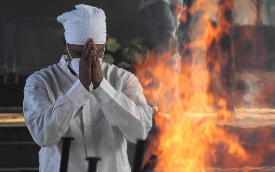 Jeev Milkha offer prayers in front of the funeral pyre of his 91-year-old father Milkha Singh who died from Covid-19 - AP