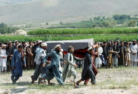 Men carry a coffin of one of the victims after a drone strike, in Khogyani district of Nangarhar province, Afghanistan