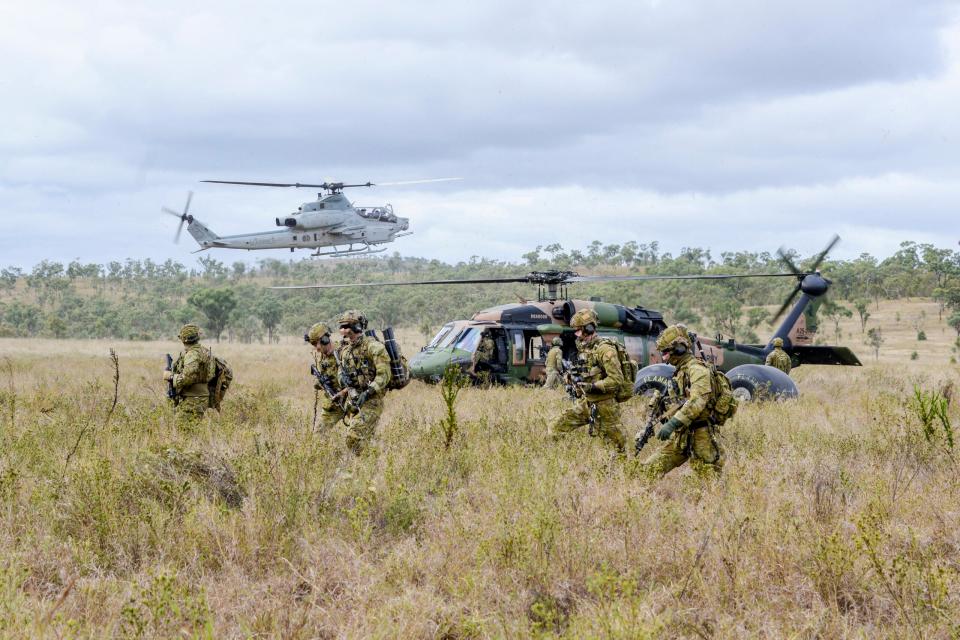Australian Army soldiers from the 2nd Commando Regiment disembark a 6th Aviation Regiment S-70A-9 Black Hawk at the High Range training area near Townsville, Queensland, during joint training with U.S. Marine Corps AH-1Z Viper gunships as part of Exercise Talisman Sabre 2019. <em>COMMONWEALTH OF AUSTRALIA, DEPARTMENT OF DEFENSE</em>