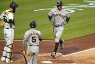 San Francisco Giants' Mike Tauchman, right, scores on an errant pickoff throw to third base by Pittsburgh Pirates catcher Jacob Stallings, left, during the fifth inning of a baseball game in Pittsburgh, Thursday, May 13, 2021.(AP Photo/Gene J. Puskar)