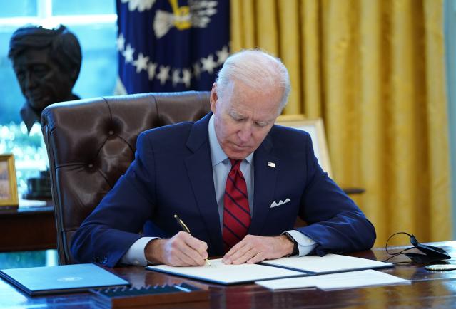 US President Joe Biden signs executive orders on health care, in the Oval Office of the White House in Washington, DC, on January 28, 2021. - The orders include reopening enrollment in the federal Affordable Care Act. (Photo by MANDEL NGAN / AFP) (Photo by MANDEL NGAN/AFP via Getty Images)