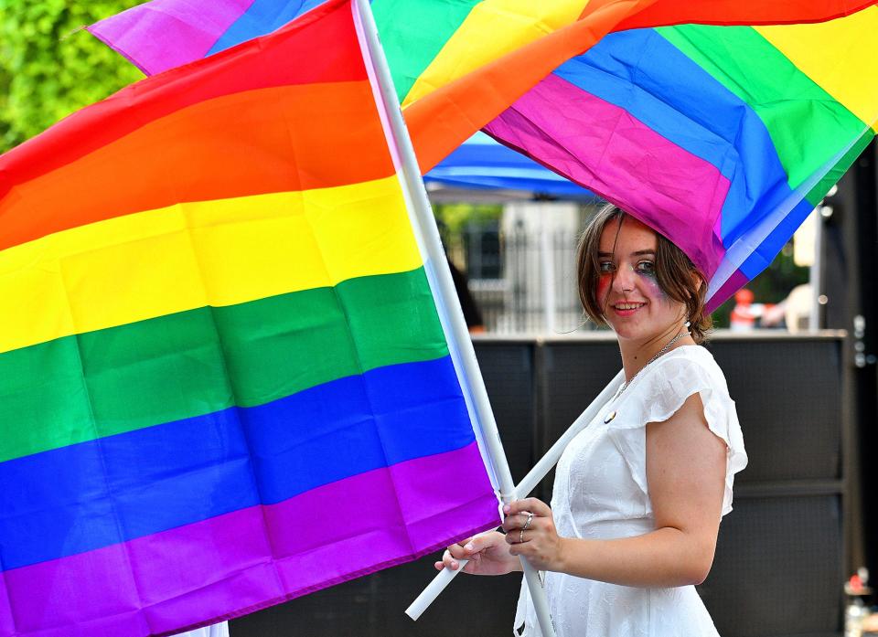 PJ Aubin of Milford, Conn., holds her own and a fellow WPI student's Pride flag during the annual Worcester Pride Festival downtown Saturday.