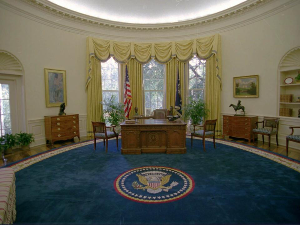 The Oval Office in 1993 featuring a blue rug and yellow curtains