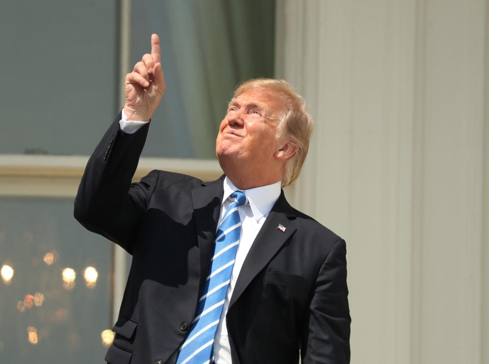 President Trump points skyward, presumably declassifying  the solar eclipse on Aug. 21, 2017, at the White House.